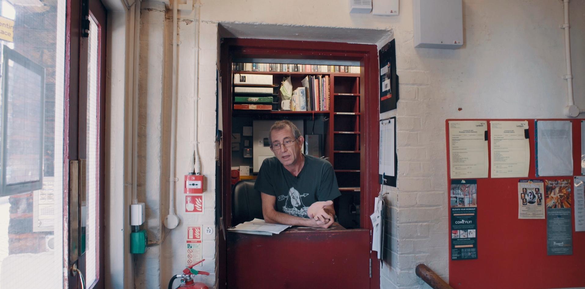 Ned Seago stands in the office at The Old Vic stage door