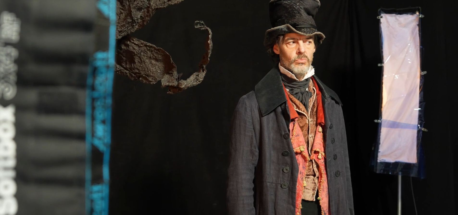 Paul Hilton dressed as Scrooge in a photography studio.