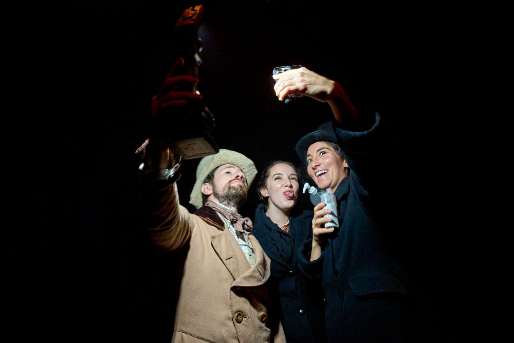 Matthew Durkan, Claire O'Leary and Parisa Shahmir take a cheerful selfie in the wings. They're in very fine Victorian costumes.