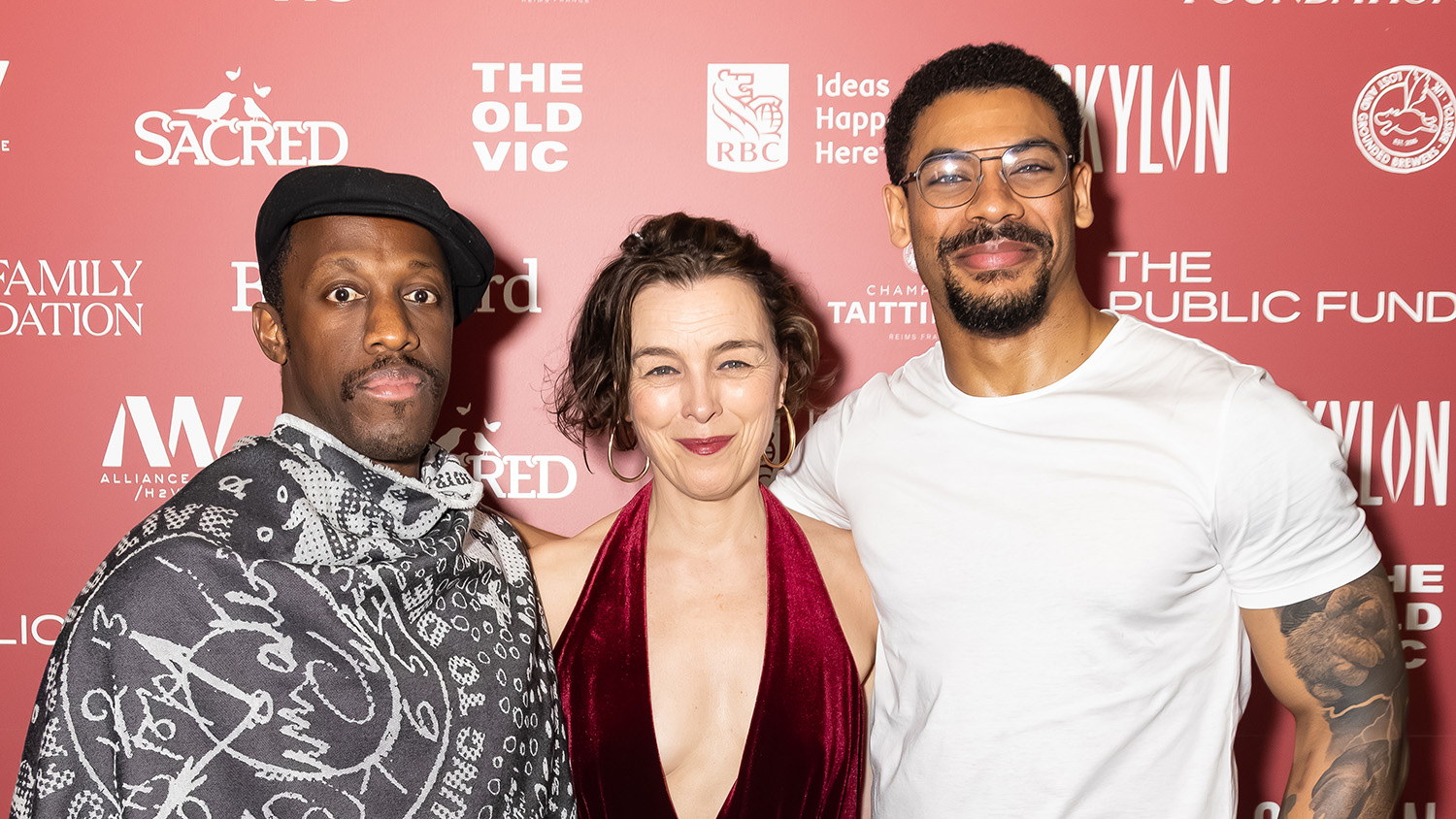 Giles Terera, Olivia Williams and Aaron Pierre pose for a photo in front of a red board of logos.