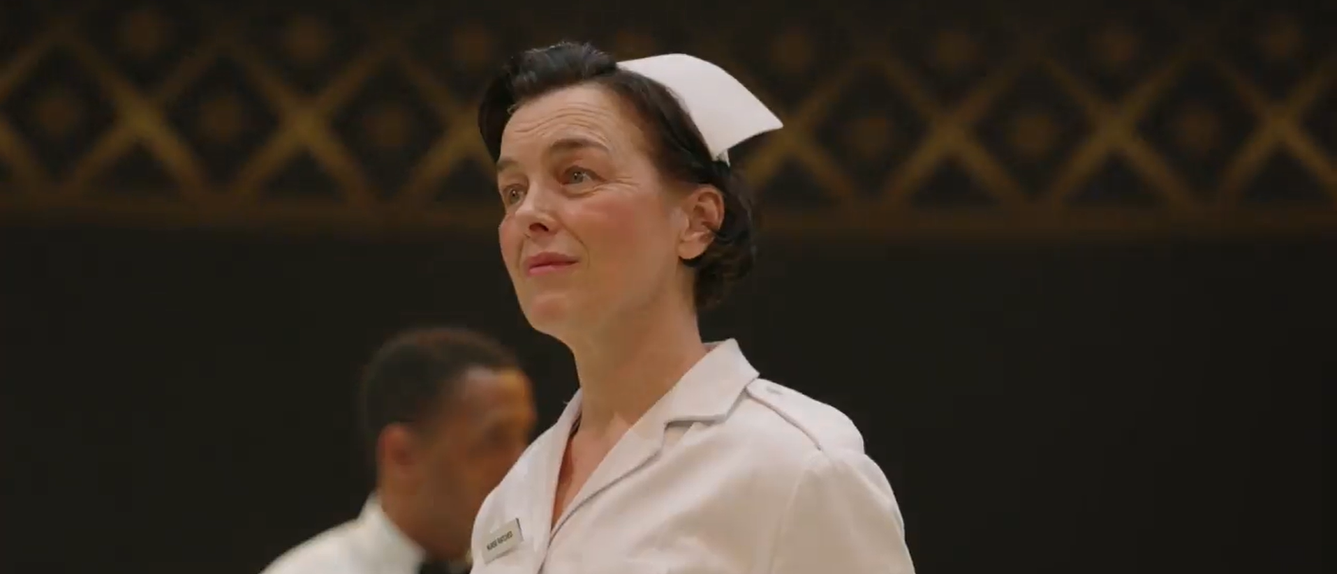 Actor Olivia Williams on stage and dressed in an old-fashioned nurse costume.