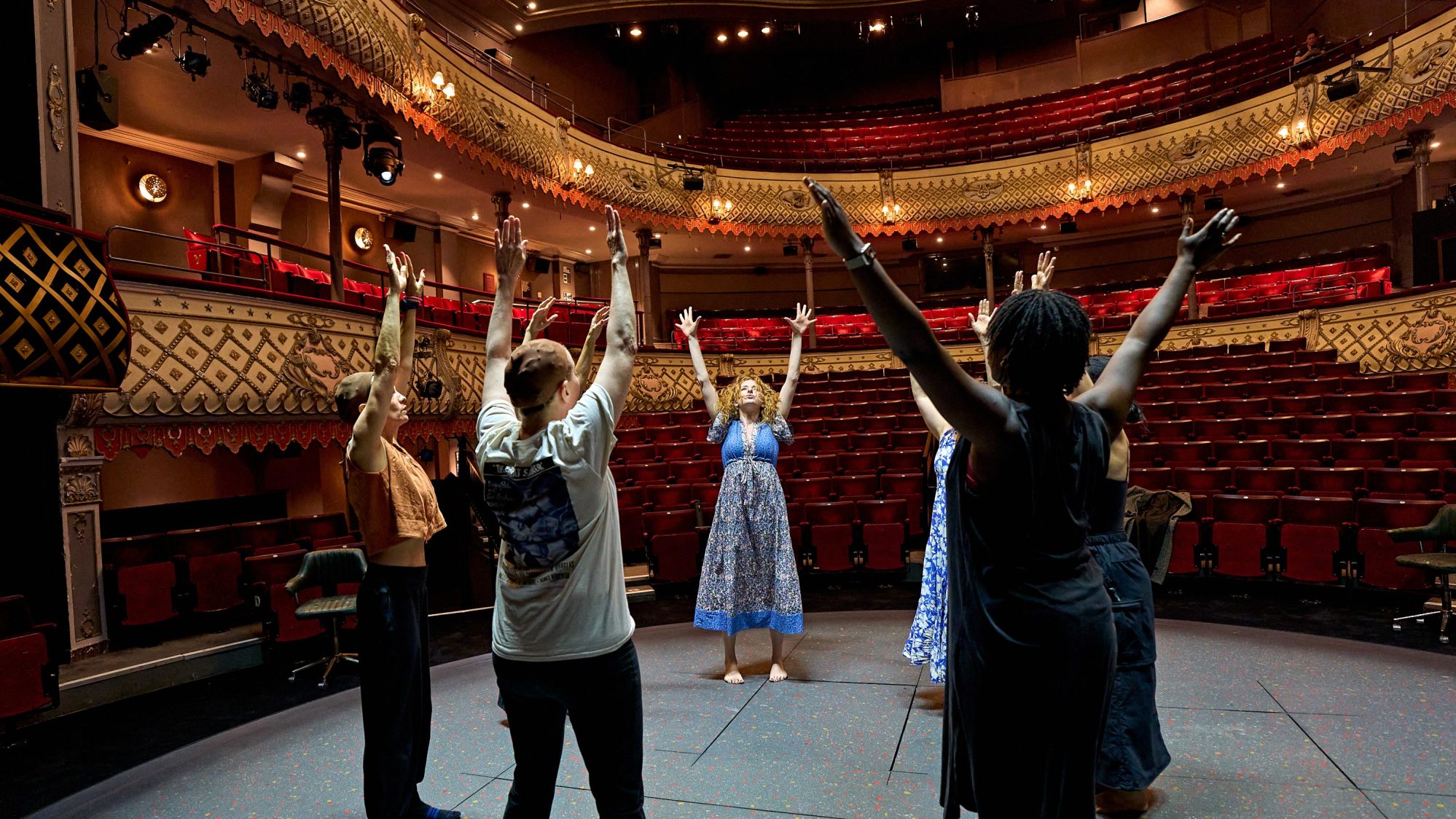 The cast of Glengarry Glen Ross stand in a circle and stretch during their pre-show warm up.