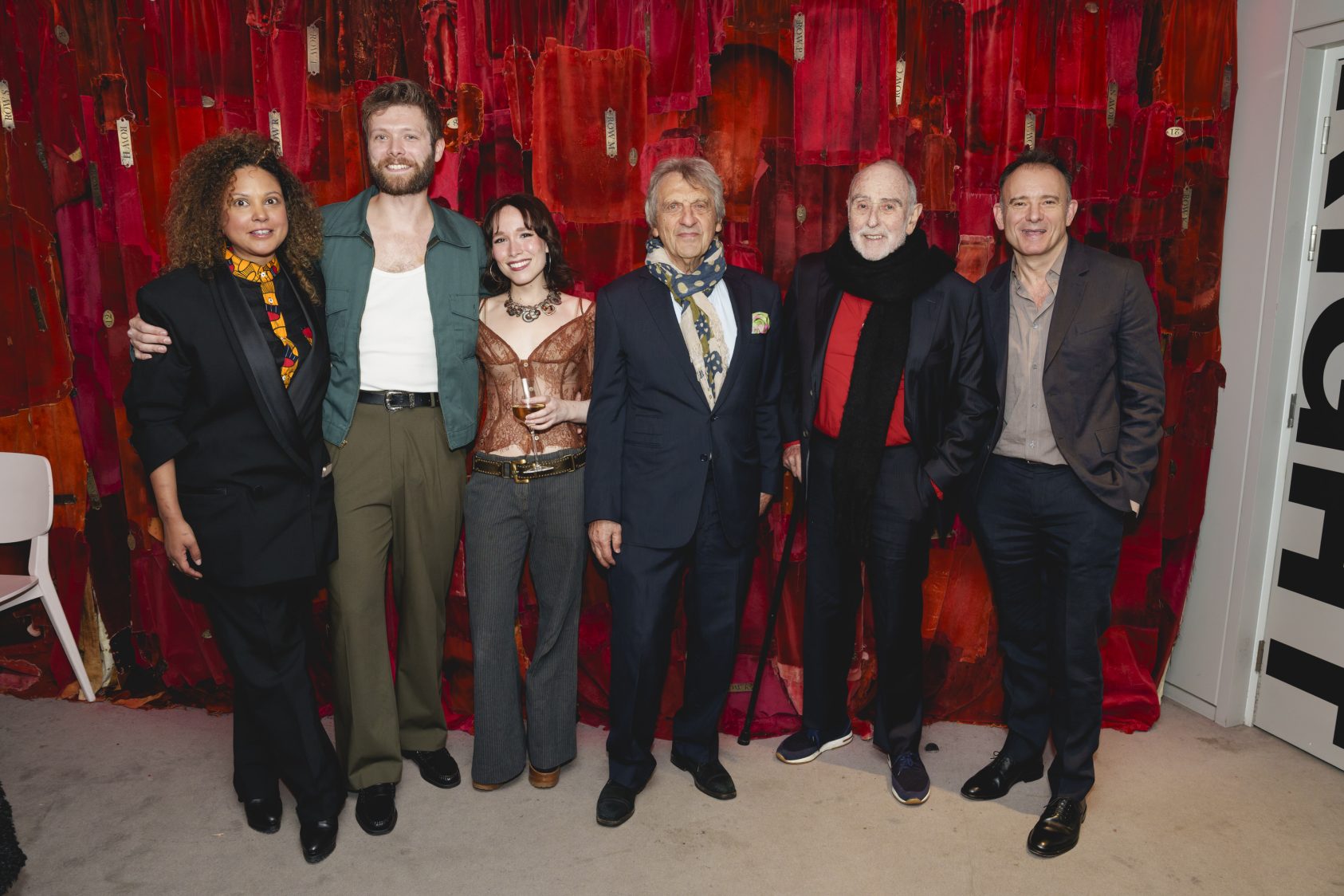 Annabel Mutale Reed, Shane O'Riordan, Liv Andrusier, Alain Boublil, Claude-Michel Schönberg and Matthew Warchus smile as they pose together in front of a wall of red velvet curtains in the foyer of The Old Vic.
